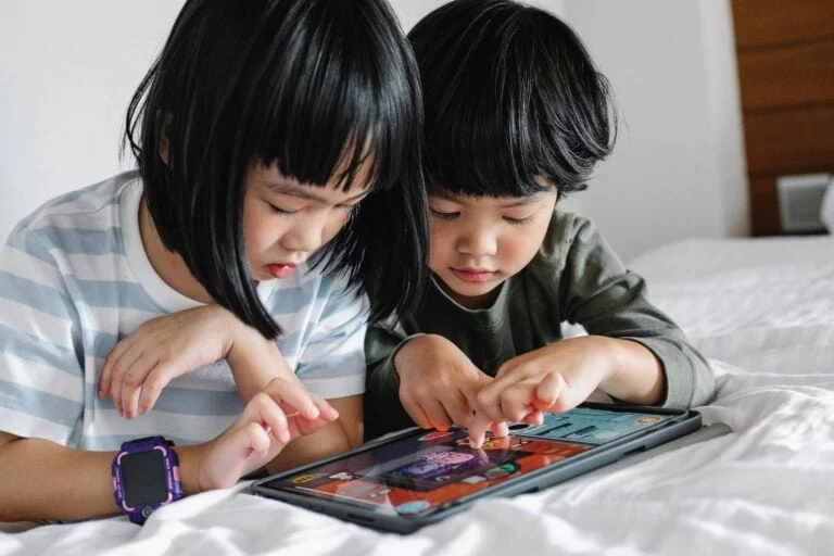 sibling are playing on a tablet