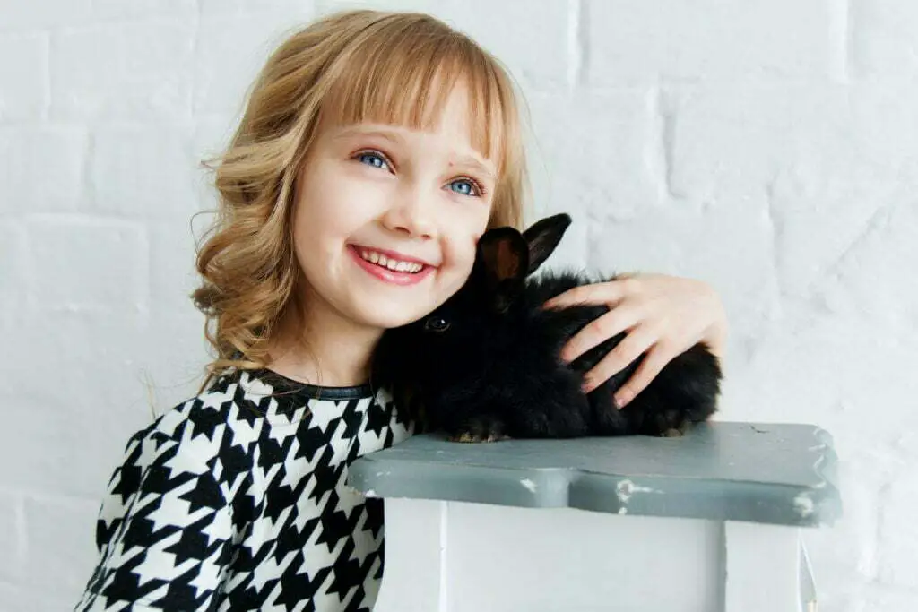 a girl is holding her pet rabbit
